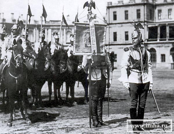 Лейб-гвардии Кирасирский Ее Императорского Величества полк на параде. На первом плане - офицеры с полковым штандартом.