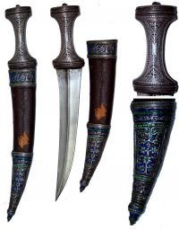 Кинжал - бебут. Сталь, серебро без пробы, кожа, эмаль, ковка, гравировка, "ложная" зернь, травление. Длина общая в ножнах — 397 мм; длина без ножен — 361 мм; длина клинка — 248 мм; ширина клинка у пяты — 47 мм.