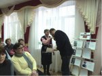 Александр Григоров целует руки внучке полного Георгиевского кавалера Михаила Акимовича Шелякина - Нине Александровне Шелякиной и вручает ей архивные документы о подвигах деда.