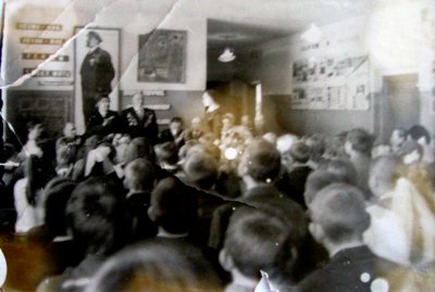 В зале школы, где проходила встреча.