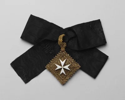 Медальон-мощевик. Первая половина XVI в., кресты - вторая половина XVIII в. Родос, кресты – Мальта, первая половина XVI в., кресты - вторая половина XVIII в. Золото, муар, монтировка, выпиловка, эмаль, скань, ткачество, высота: 78 мм (с ушком); ширина: 66 мм; ширина: 47 мм (ленты). Принадлежал Великому магистру Ордена Св. Иоанна Иерусалимского (Мальтийского) Филиппу Вилье де л'Иль-Адаму